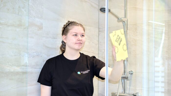 Siivouspalvelu Vidgrenin siivooja pesee suihkuseinää